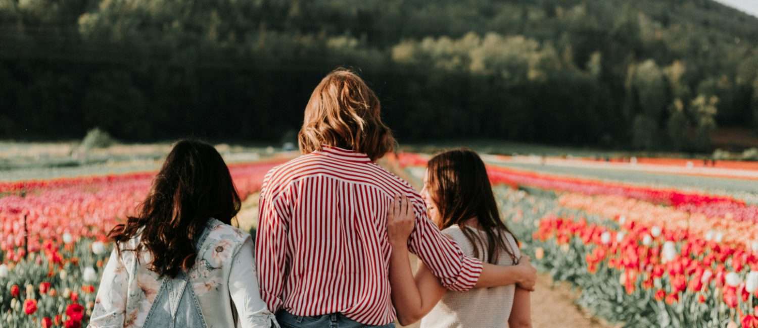 Three women in a field of flowers