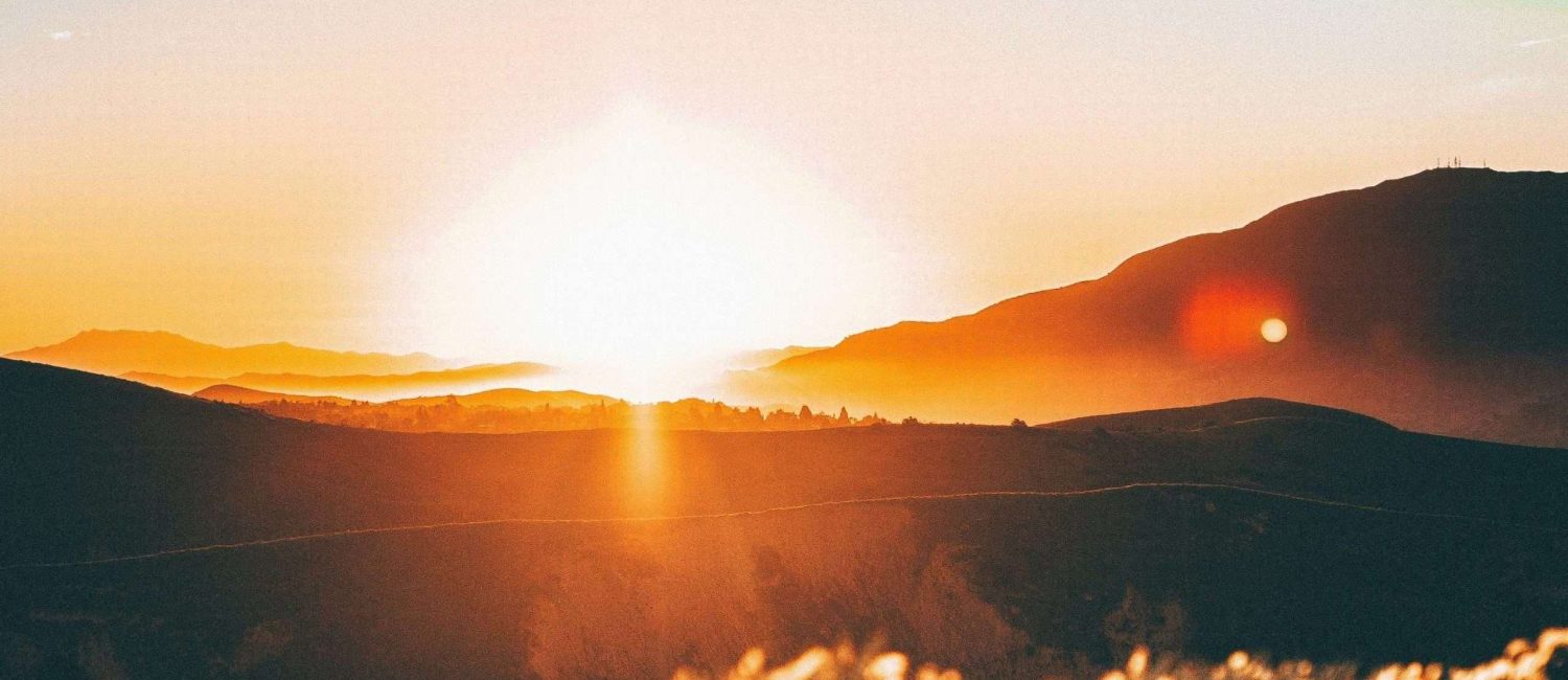 Sun setting behind hills