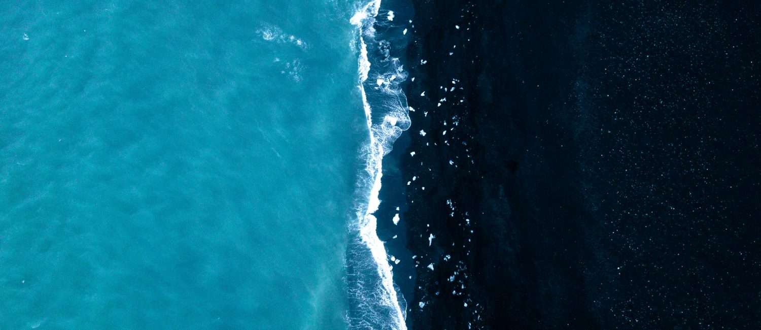 Aerial view of ocean water with a vertical separation of dark and light blue waters